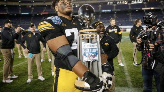 Iowa junior right tackle Tristan Wirfs holds the Holiday Bowl trophy after the Hawkeyes beat USC, 49-24, Dec. 27, 2019 at the SDCCU Stadium in San Diego.