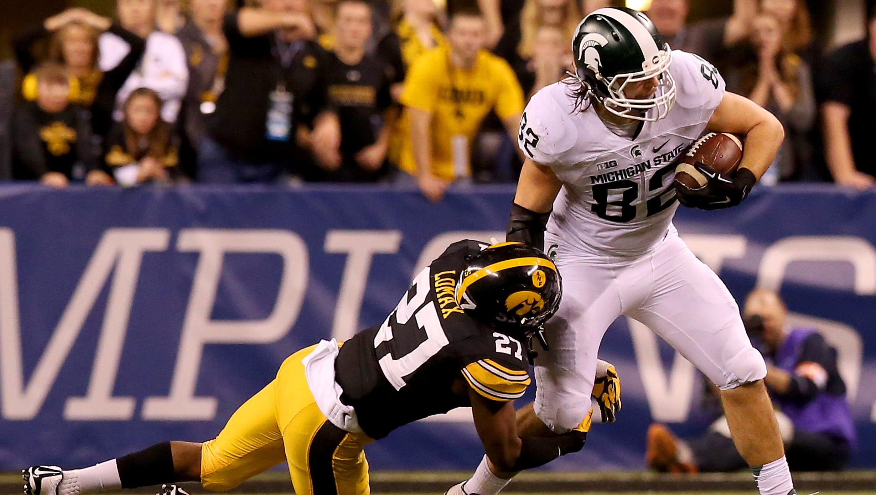 Michigan State tight end Josiah Price (82) breaks a tackle by Iowa defensive back Jordan Lomax (27) during the Big Ten Championship Game at Lucas Oil Stadium on Dec. 5, 2015.