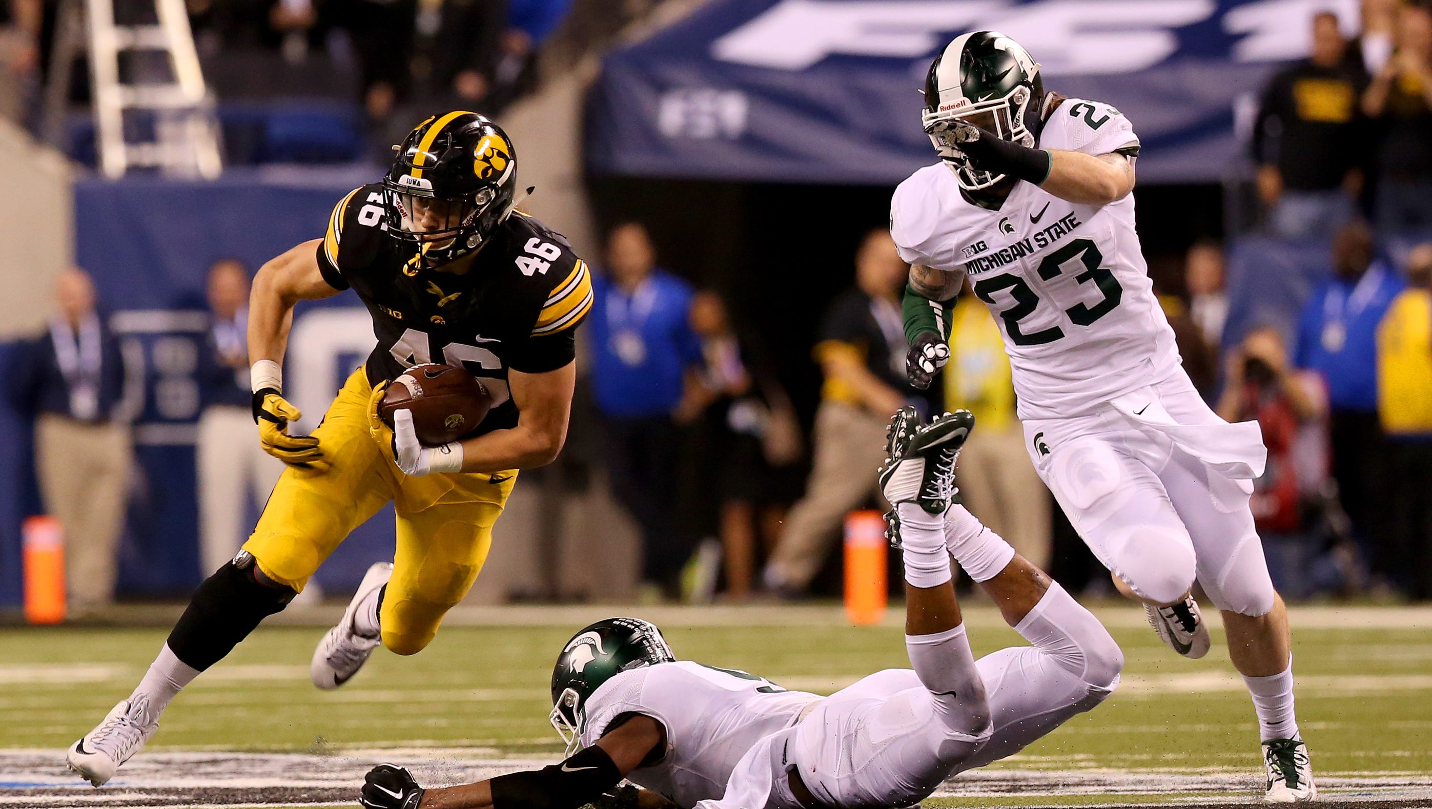 Iowa tight end George Kittle (46) makes Michigan State safety Montae Nicholson (9) miss on the tackle and gets the first down on a long third down against Michigan State during the Big Ten Championship Game at Lucas Oil Stadium on Dec. 5, 2015.