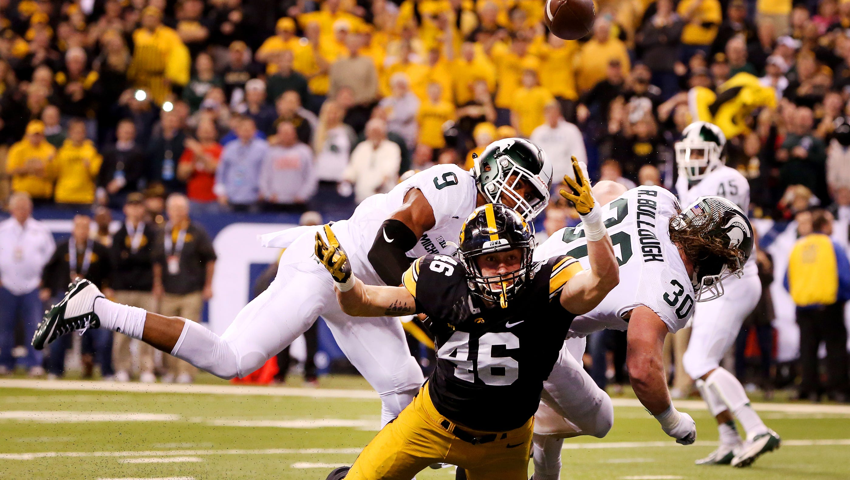Iowa tight end George Kittle (46) is hit as he attempted a catch in the end zone by Michigan State linebacker Riley Bullough (30) during the Big Ten Championship Game at Lucas Oil Stadium on Dec. 5, 2015. The pass was later intercepted.