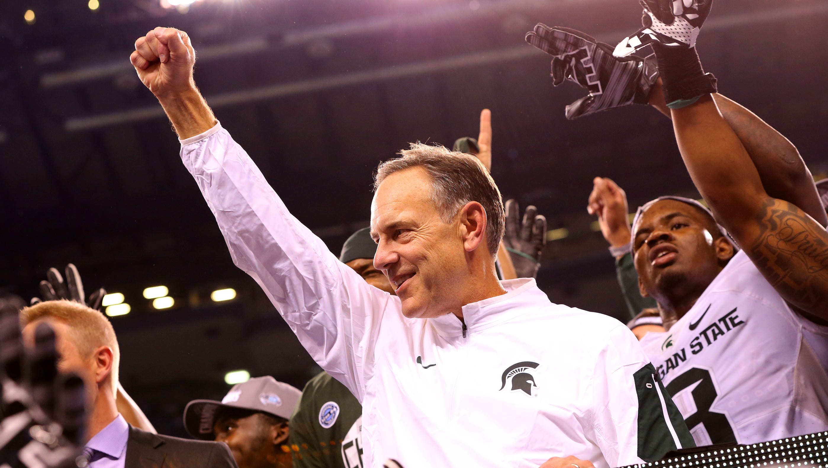 Michigan State head football coach Mark Dantonio steps on stage to receive the Amos Alonzo Stagg Championship Trophy after defeating Iowa in the Big Ten Championship Game at Lucas Oil Stadium on Dec. 5, 2015.