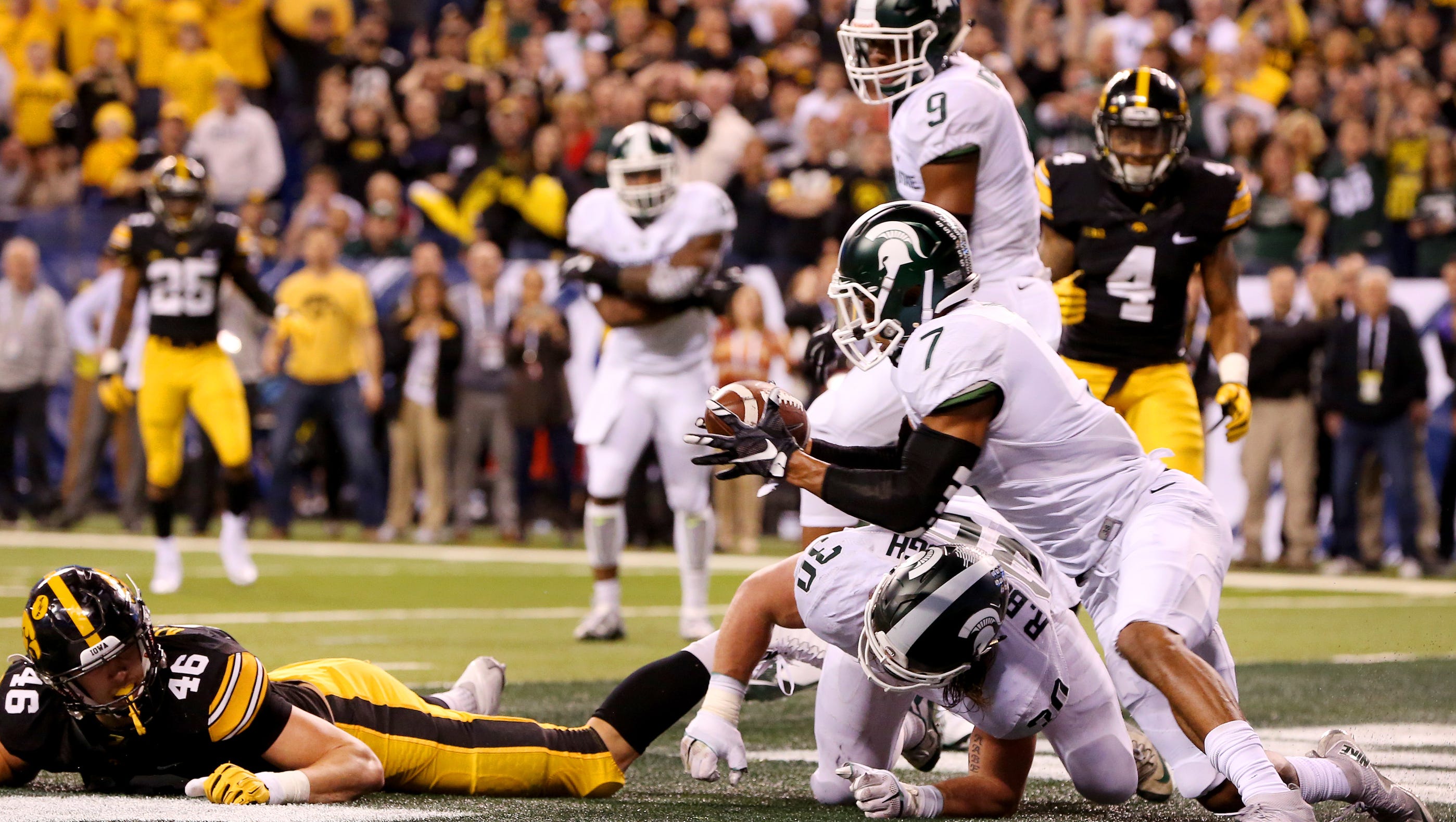 After the ball was tipped by Michigan State linebacker Riley Bullough (30) and landed on his back, defensive back Demetrious (7) picks off the ball for the turnover against Iowa during the Big Ten Championship Game at Lucas Oil Stadium on Dec. 5, 2015.
