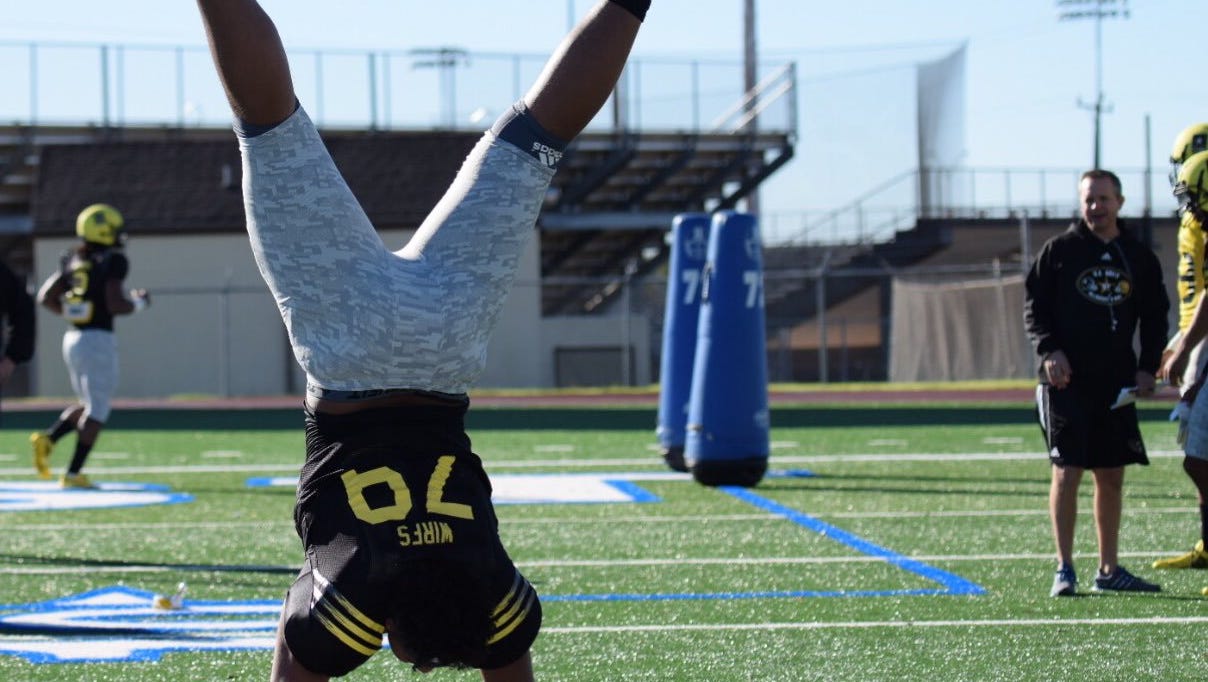 Mount Vernon standout and Iowa offensive lineman signee Tristan Wirfs does a handstand during a January practice for the US Army All American Bowl in San Antonio.
