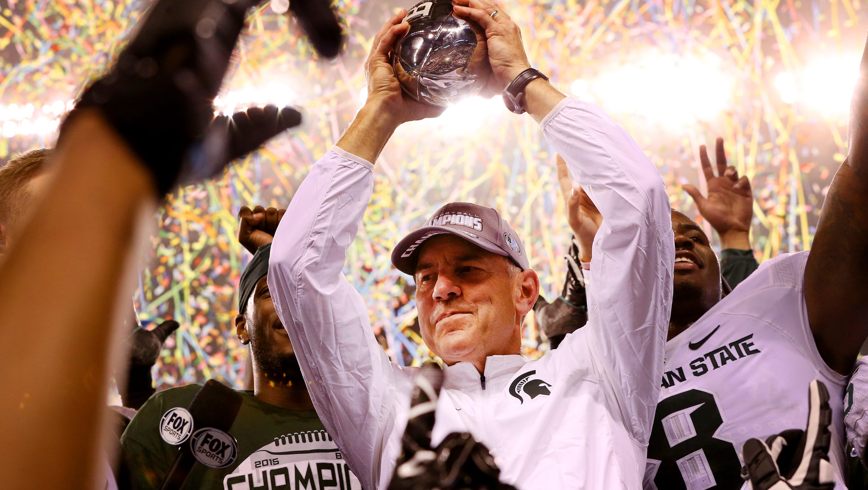 Michigan State head football coach Mark Dantonio holds up the Amos Alonzo Stagg Championship Trophy after the win against Iowa in the Big Ten Championship Game at Lucas Oil Stadium on Dec. 5, 2015.