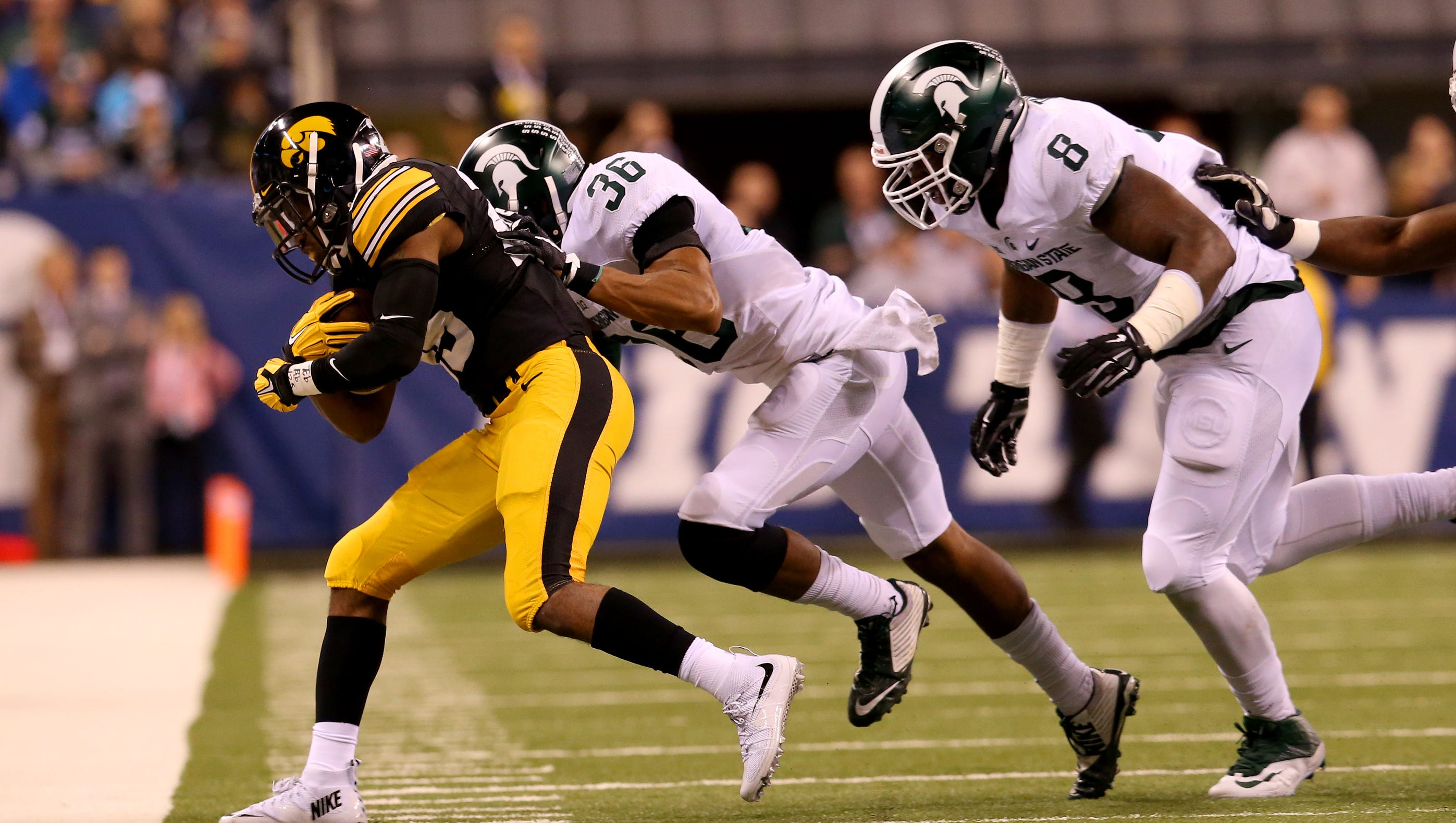 Iowa running back Akrum Wadley (25) is drove out of bounds by Michigan State cornerback Arjen Colquhoun (36) during the Big Ten Championship Game at Lucas Oil Stadium on Dec. 5, 2015.