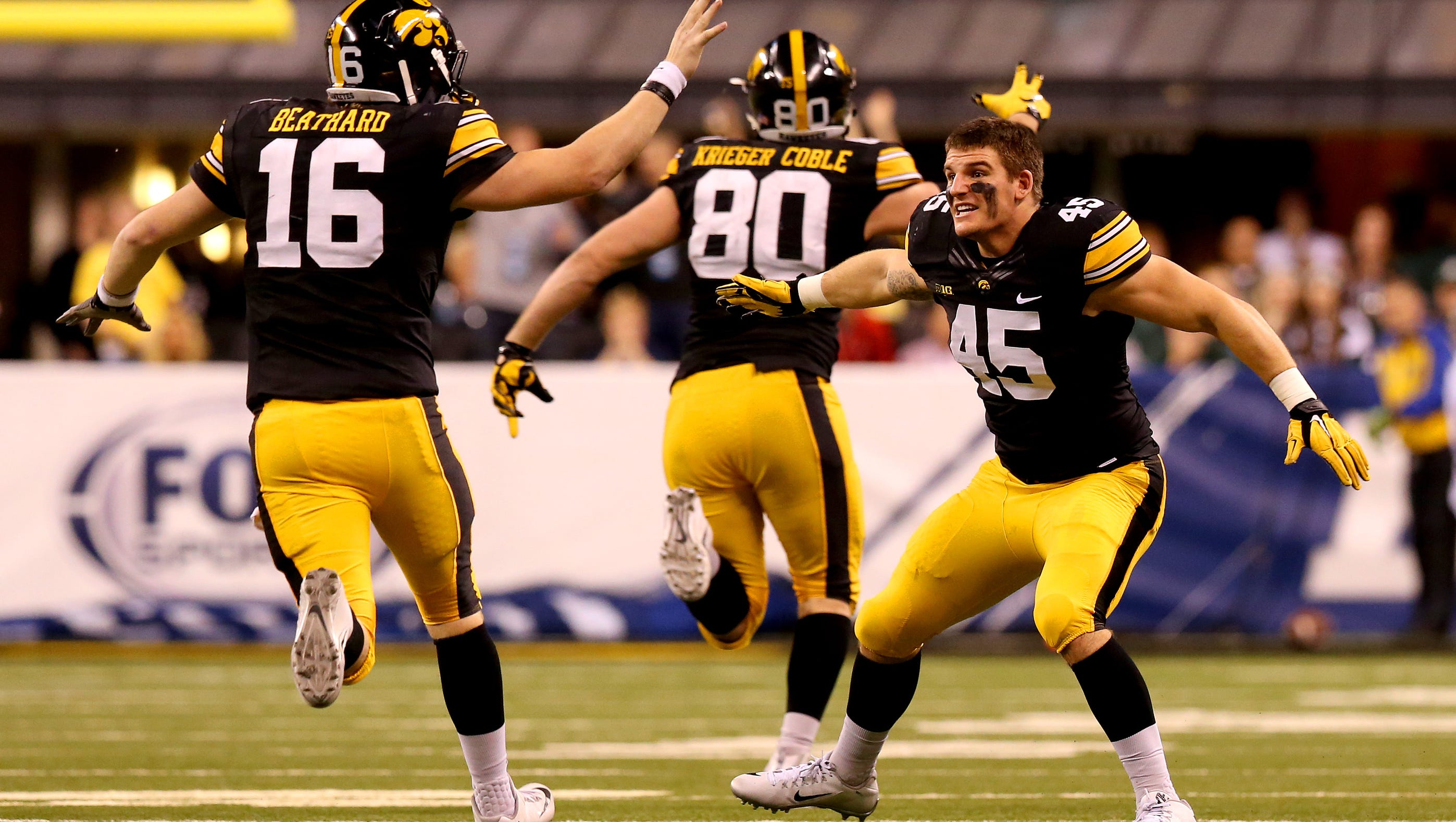 Iowa quarterback C.J. Beathard (16) is congratulated by Iowa linebacker Eric Grimm (45) after throwing a long touchdown pass late in the fourth quarter against Michigan State during the Big Ten Championship Game at Lucas Oil Stadium on Dec. 5, 2015.