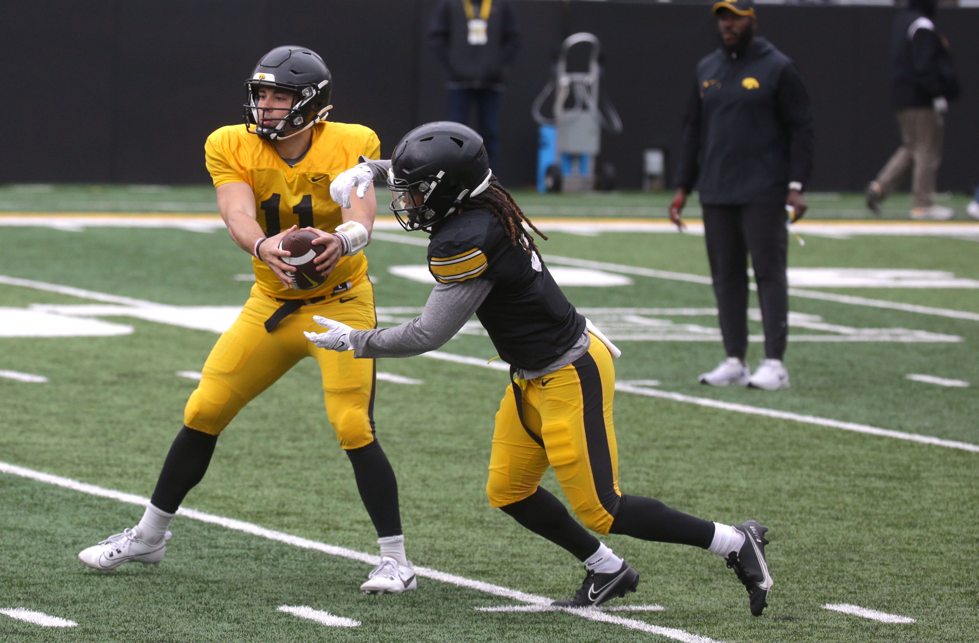 Iowa Hawkeyes quarterback Marco Lainez (11) hands the ball to running back Terrell Washington Jr. (9) during an open spring practice Saturday, April 20, 2024 at Kinnick Stadium in Iowa City, Iowa.