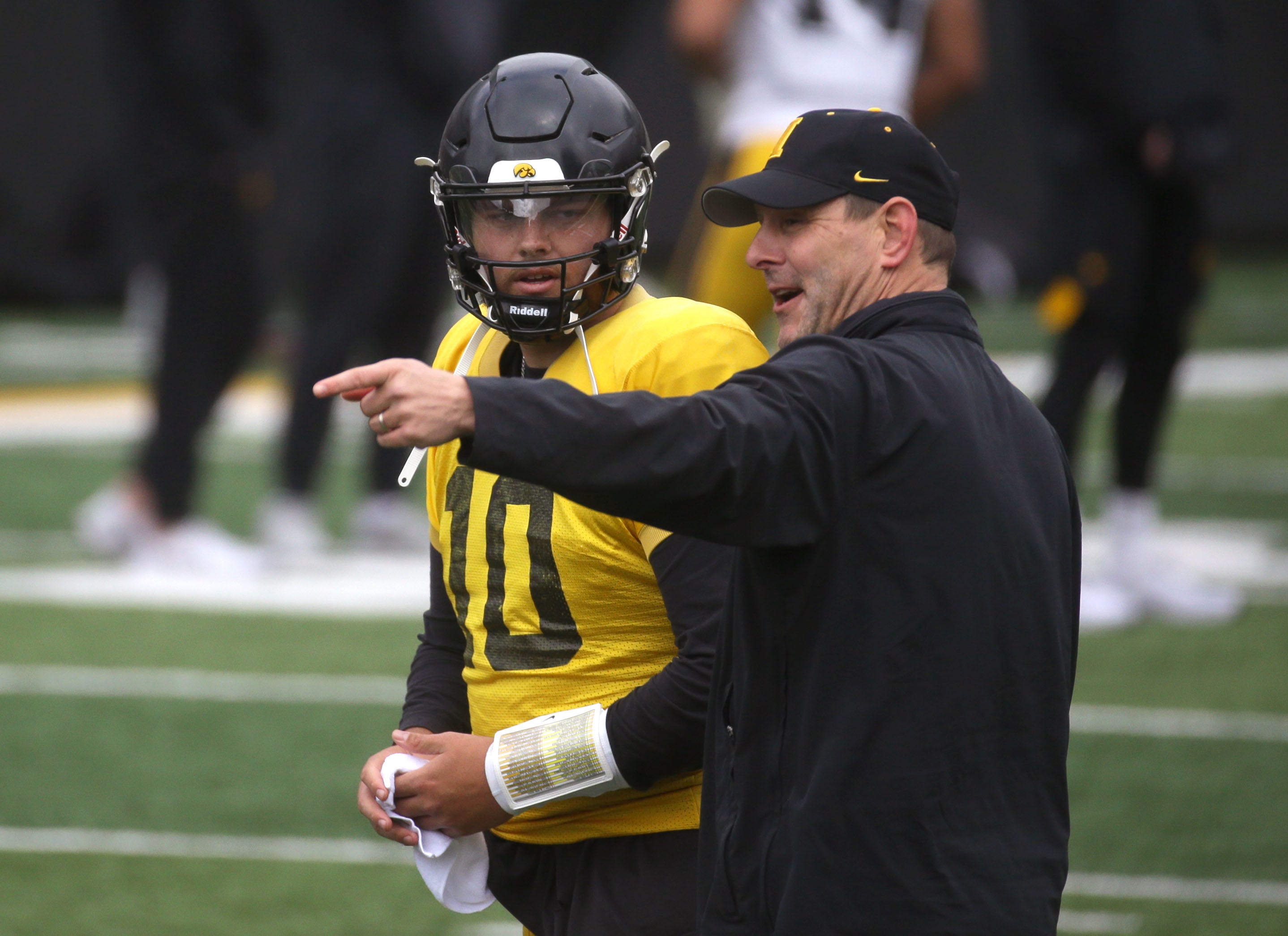 Iowa Hawkeyes offensive coordinator Tim Lester, right, talks to quarterback Deacon Hill (10) during an open spring practice Saturday, April 20, 2024 at Kinnick Stadium in Iowa City, Iowa.