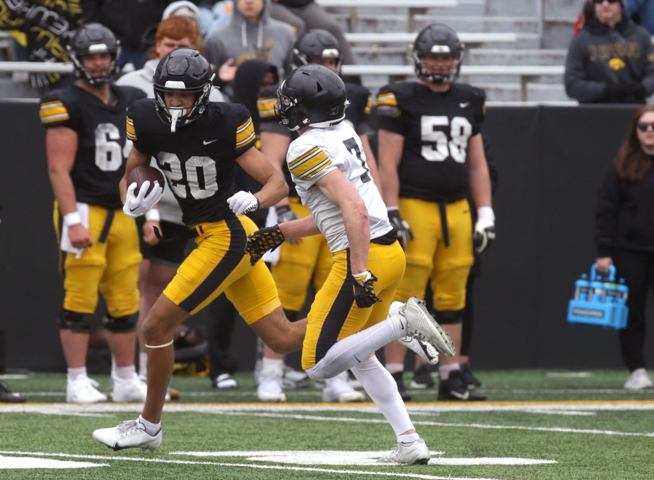 Iowa Hawkeyes wide receiver Watts McBride (20) runs for extra yards after a catch as defensive back John Nestor (7) chases him down during an open spring practice Saturday, April 20, 2024 at Kinnick Stadium in Iowa City, Iowa.