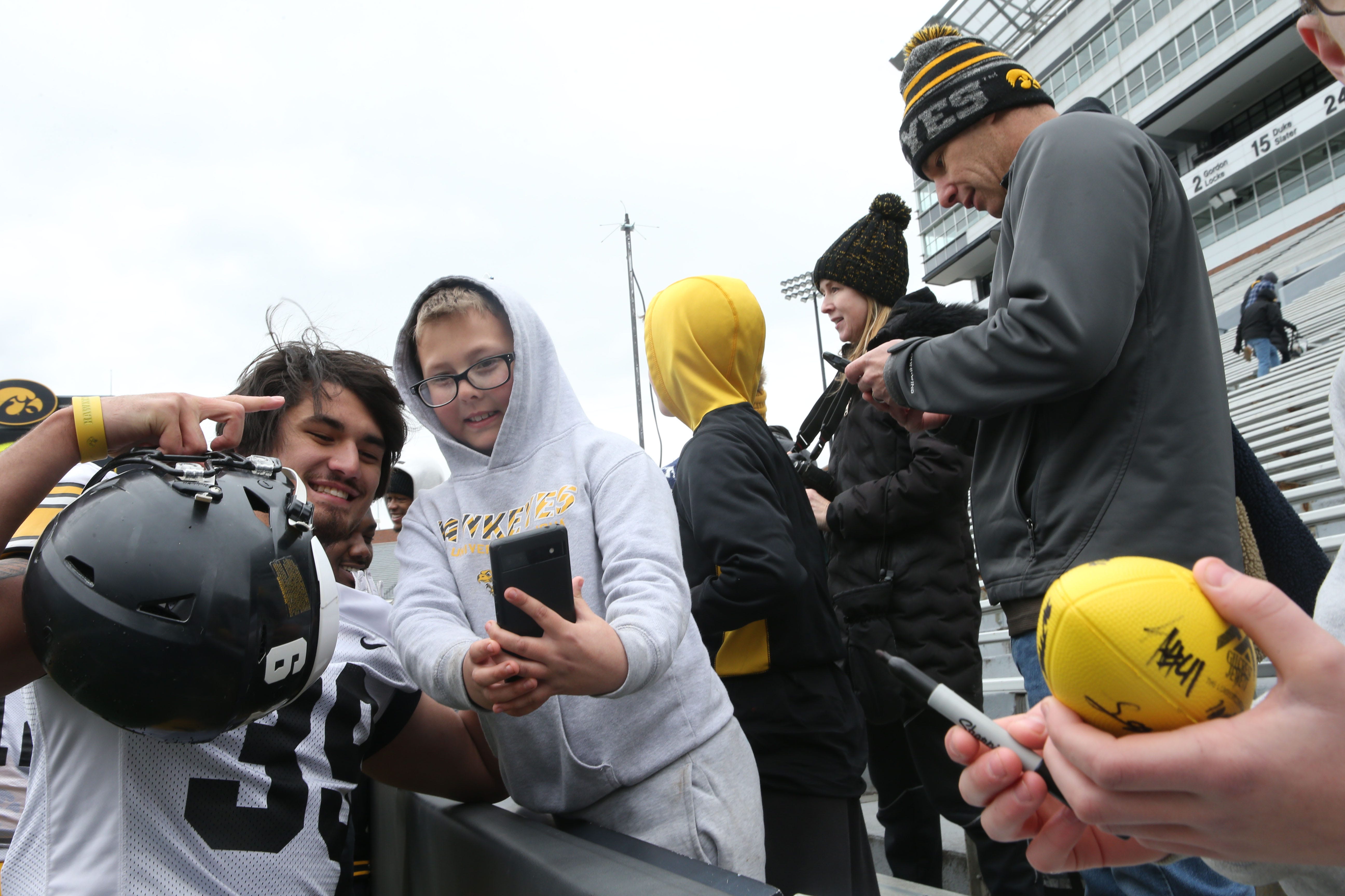 Iowa Hawkeyes linebacker Eric Epenesa (39 takes a selfie with a fan after an open spring practice Saturday, April 20, 2024 at Kinnick Stadium in Iowa City, Iowa.