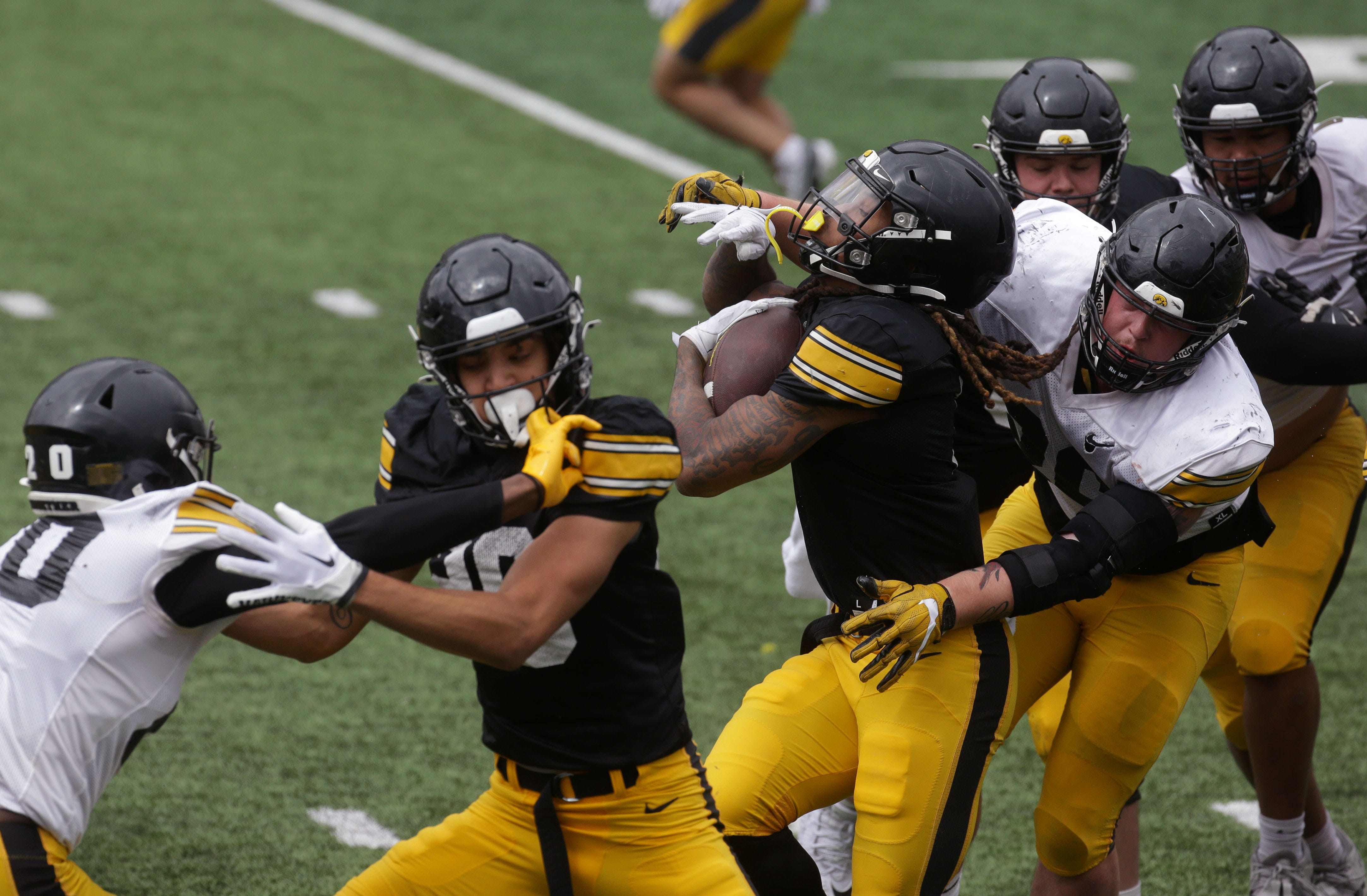 Iowa Hawkeyes Jaziun Patterson (9), fourth from right, attempts to break a tackle during an open spring practice Saturday, April 20, 2024 at Kinnick Stadium in Iowa City, Iowa.