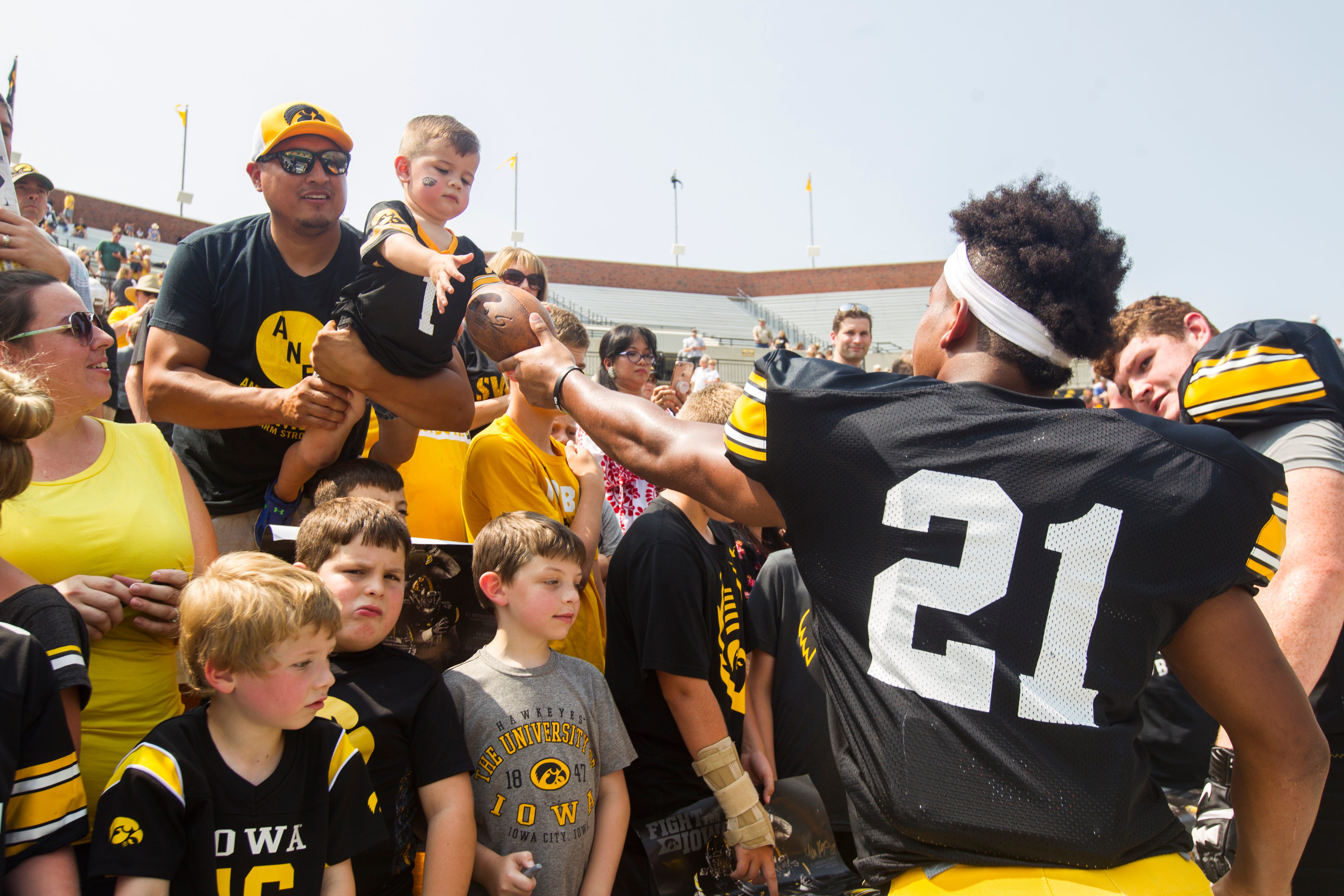 Iowa running back Ivory Kelly-Martin hands a signed football to a young fan during a Kids Day practice on Saturday, Aug. 11, 2018, at Kinnick Stadium in Iowa City.