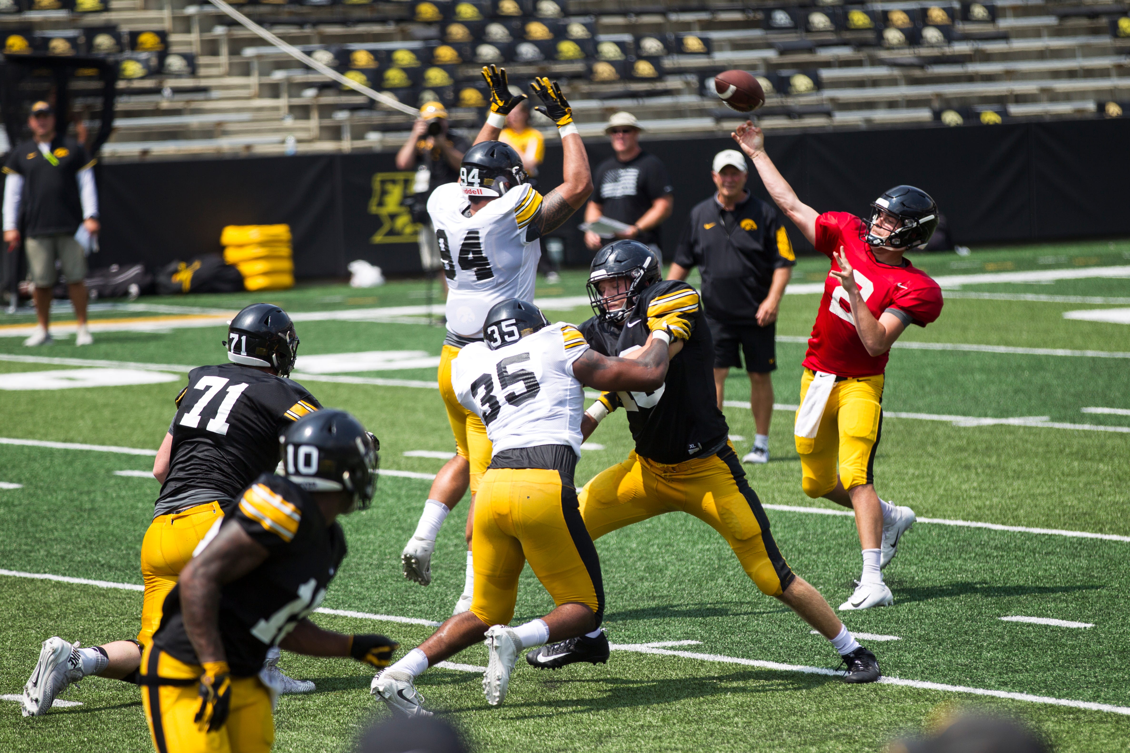 Iowa quarterback Peyton Mansell throws a pass while defensive end A.J. Epenesa gets his hands up during a Kids Day practice on Saturday, Aug. 11, 2018, at Kinnick Stadium in Iowa City.