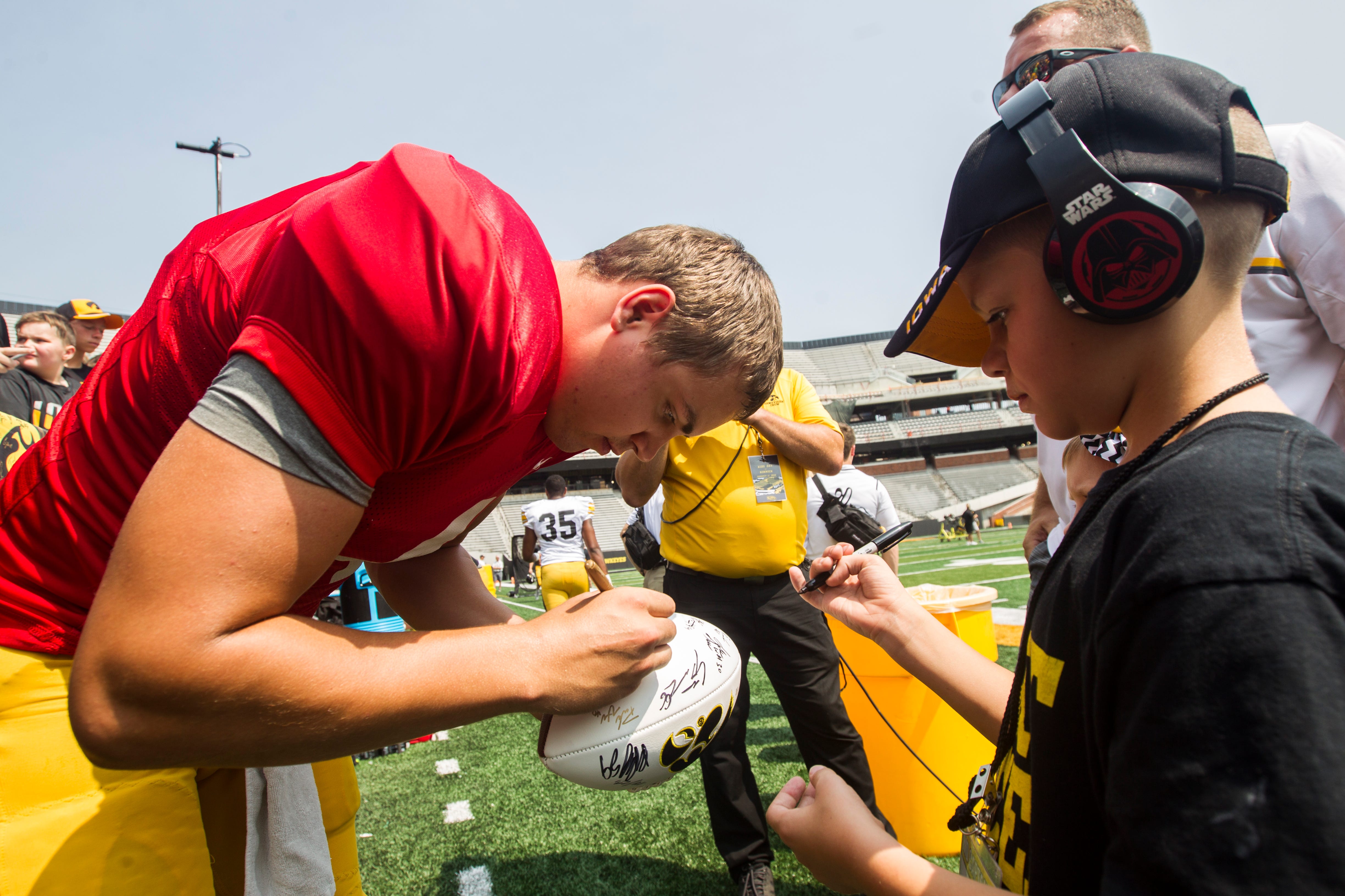 Iowa quarterback Nate Stanley signs a football for a fan during a Kids Day practice on Saturday, Aug. 11, 2018, at Kinnick Stadium in Iowa City.