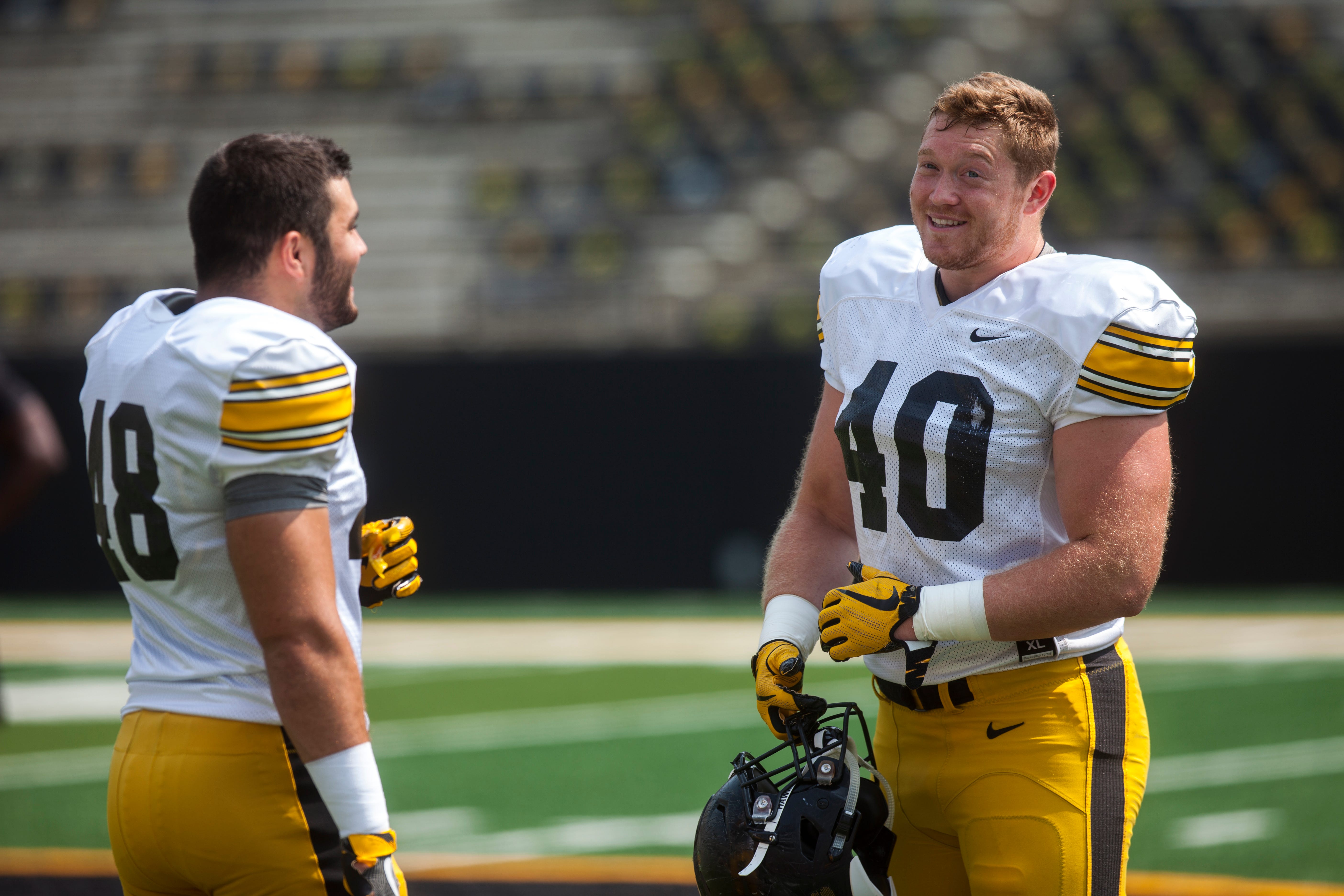 Iowa linebacker Jack Hockaday talks with defensive end Parker Hesse during a Kids Day practice on Saturday, Aug. 11, 2018, at Kinnick Stadium in Iowa City.