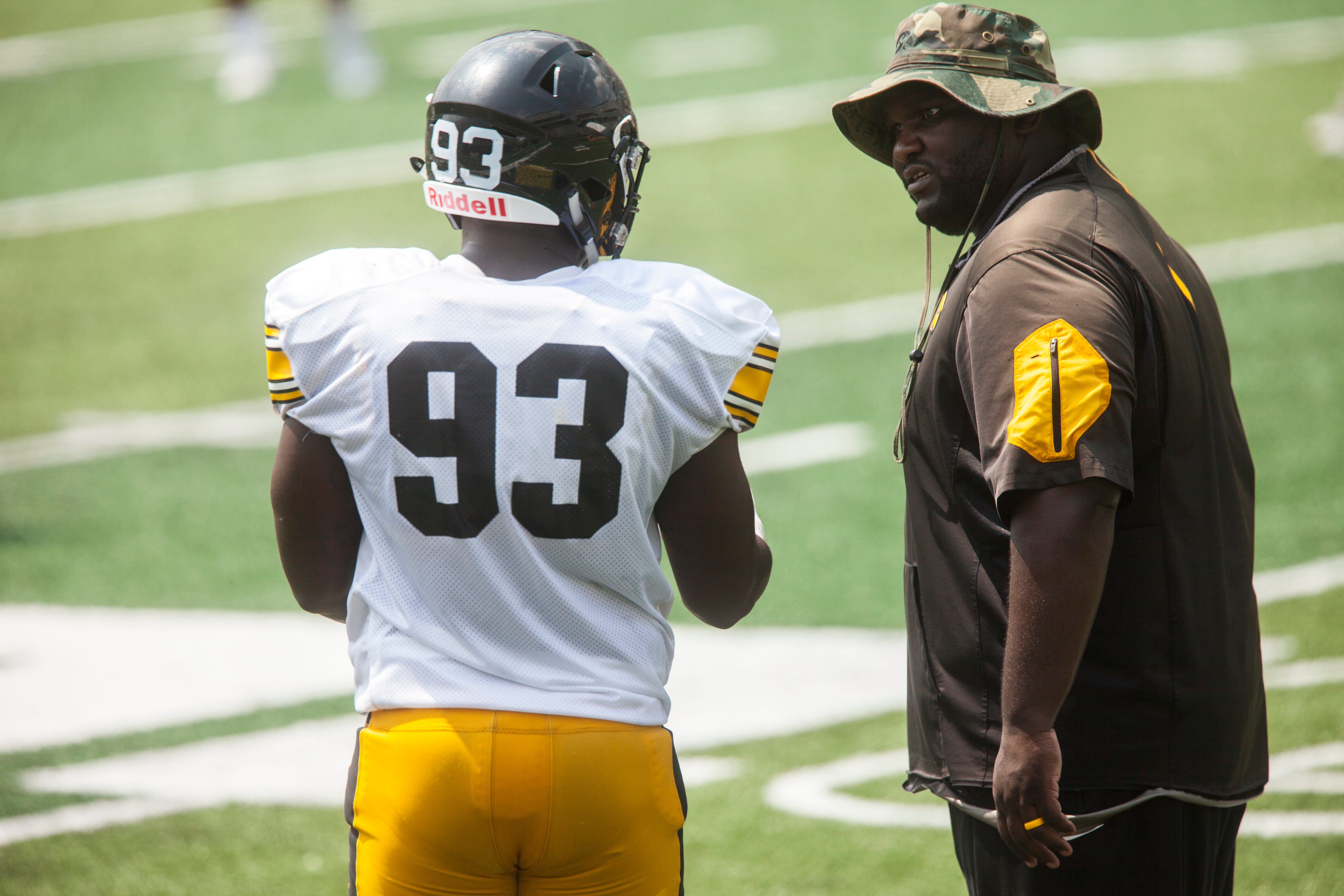 Iowa assistant defensive line coach Kelvin Bell talks with defensive end Brandon Simon during a Kids Day practice on Saturday, Aug. 11, 2018, at Kinnick Stadium in Iowa City.