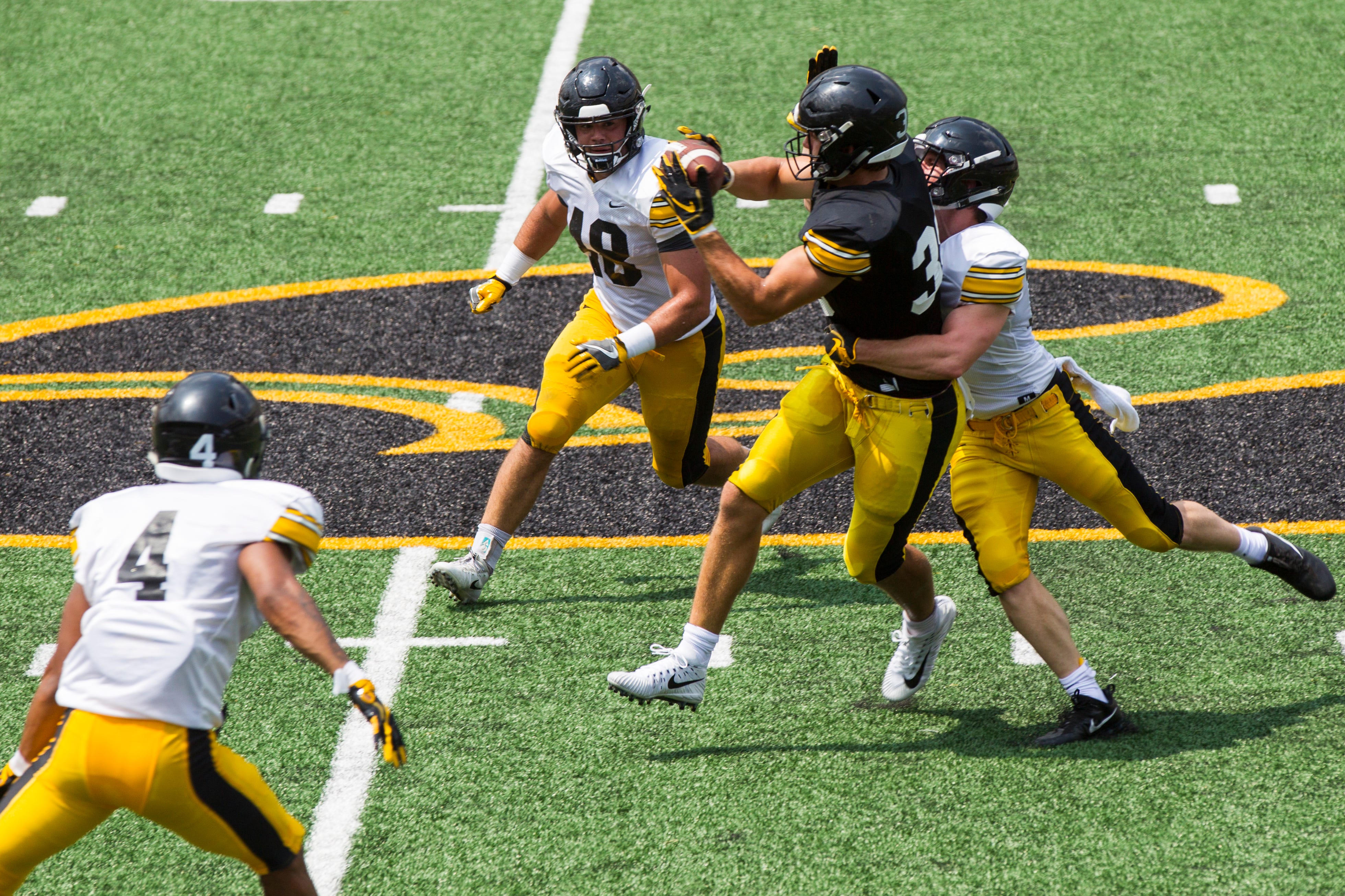 Iowa tight end T.J. Hockenson catches a pass while being covered by defensive back John Milani and during a Kids Day practice on Saturday, Aug. 11, 2018, at Kinnick Stadium in Iowa City.