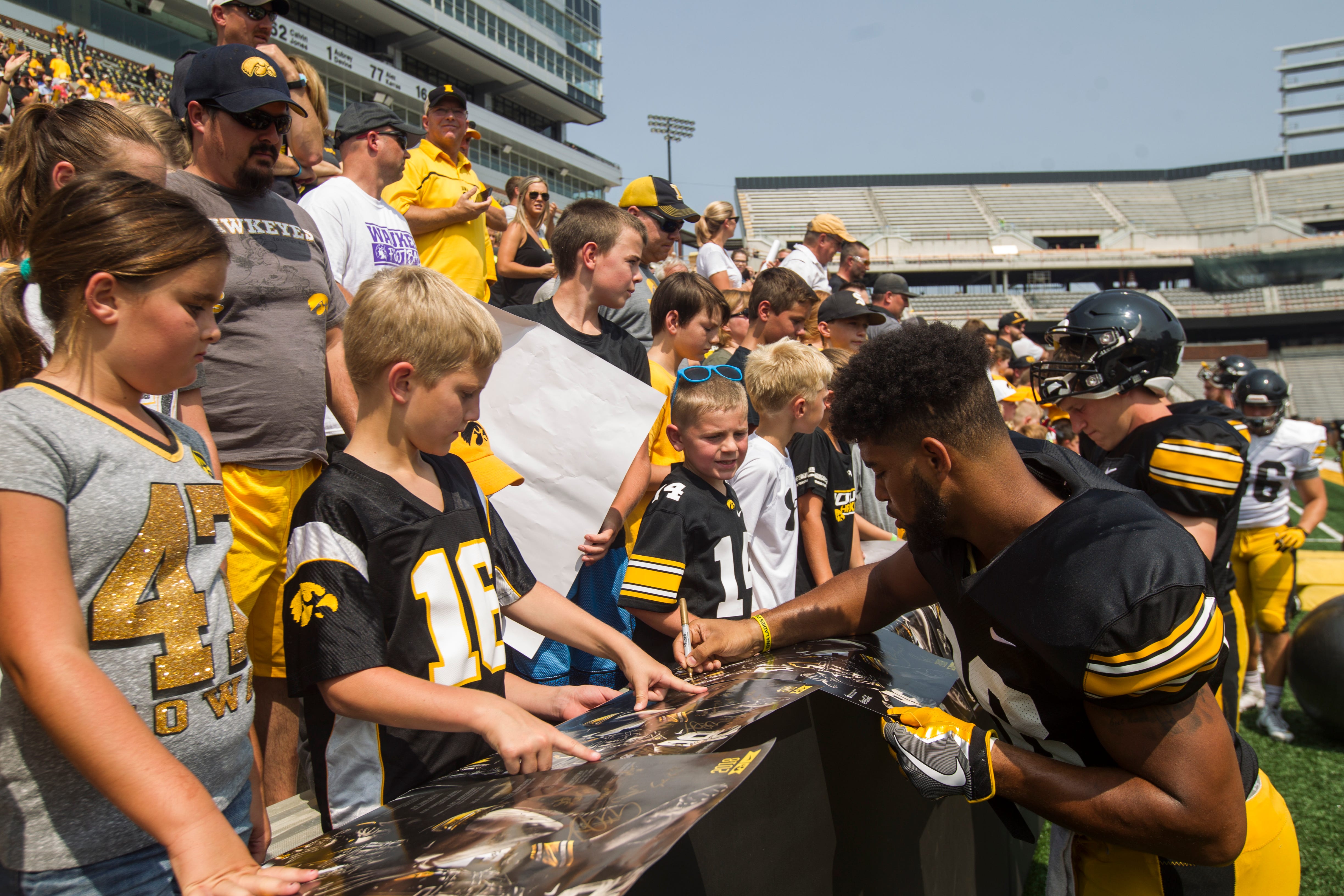 Iowa running back Toren Young signs autographs for fans during a Kids Day practice on Saturday, Aug. 11, 2018, at Kinnick Stadium in Iowa City.