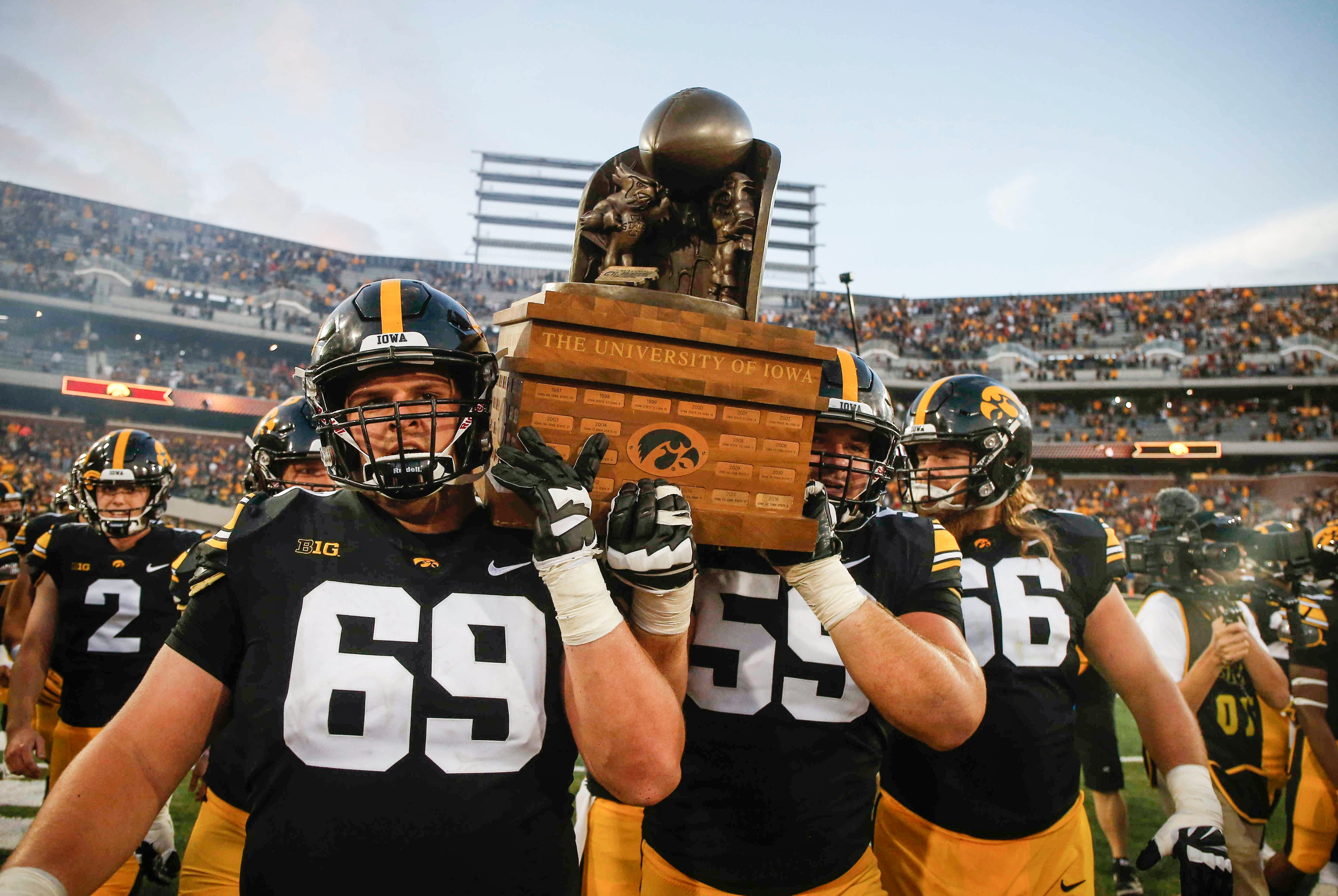 Members of the Iowa Hawkeyes football team carry the CyHawk trophy off the field after a 13-3 win over Iowa State on Saturday, Sept. 8, 2018, at Kinnick Stadium in Iowa City.