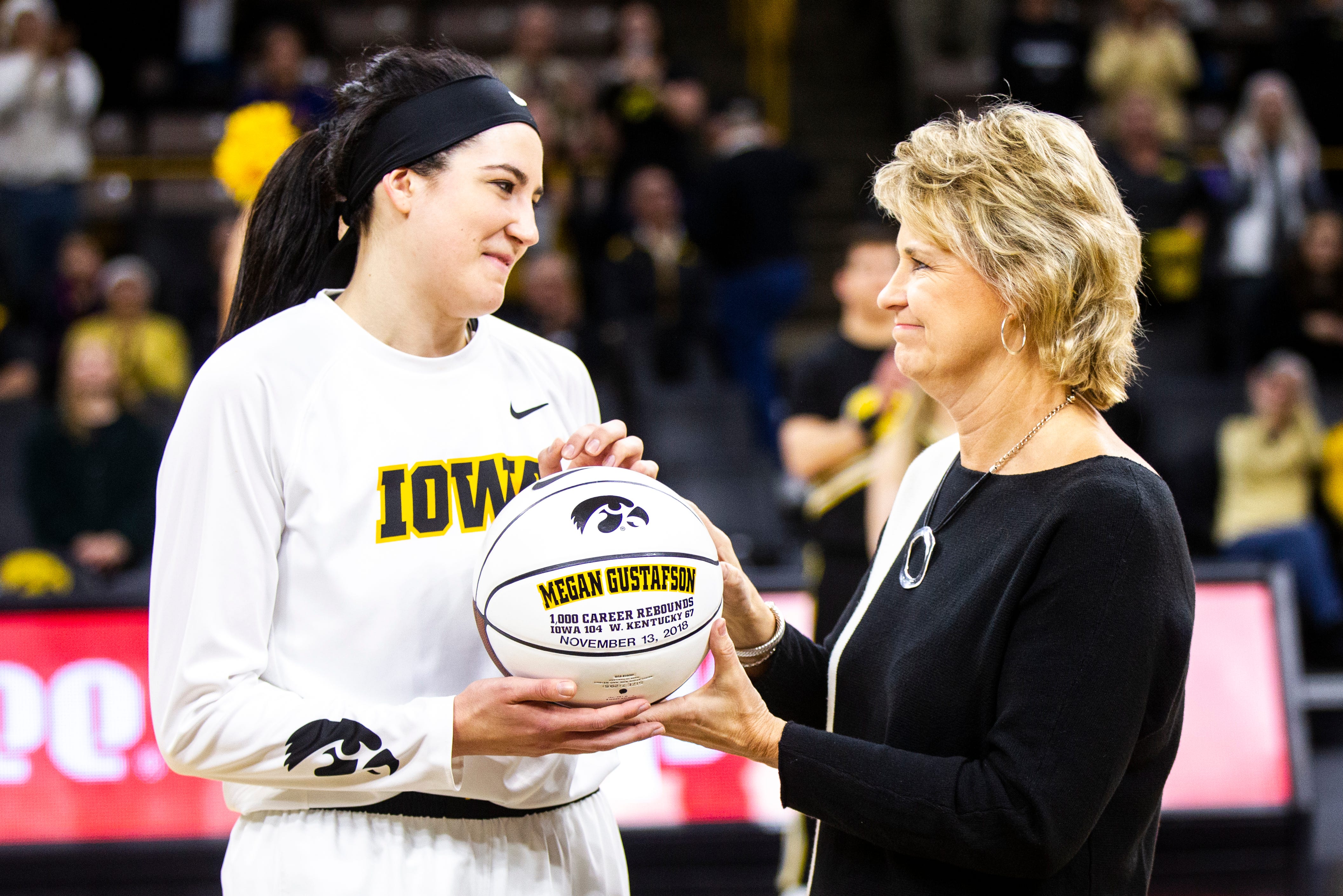 Iowa forward Megan Gustafson (10) is handed a ball acknowledging her 1,000 career rebounds by Iowa head coach Lisa Bluder before a NCAA women's basketball game on Saturday, Dec. 8, 2018, at Carver-Hawkeye Arena in Iowa City. Gustafson broke the Iowa rebounding record on Wednesday Dec. 5 against the Iowa State Cyclones.
