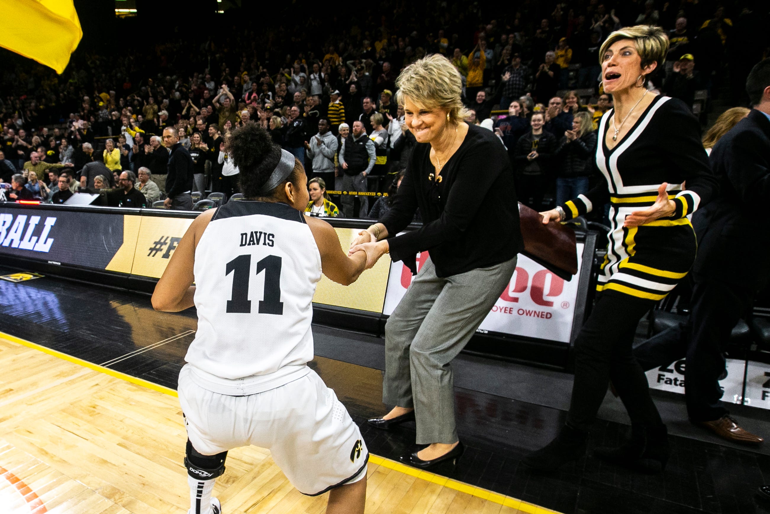Iowa guard Tania Davis (11) shakes hands with Iowa head coach Lisa Bluder as Jan Jensen celebrates after a NCAA Big Ten Conference women's basketball game on Wednesday, Jan. 23, 2019, at Carver-Hawkeye Arena in Iowa City, Iowa.  The Hawkeyes defeated Rutgers' Scarlet Knights, 72-66.