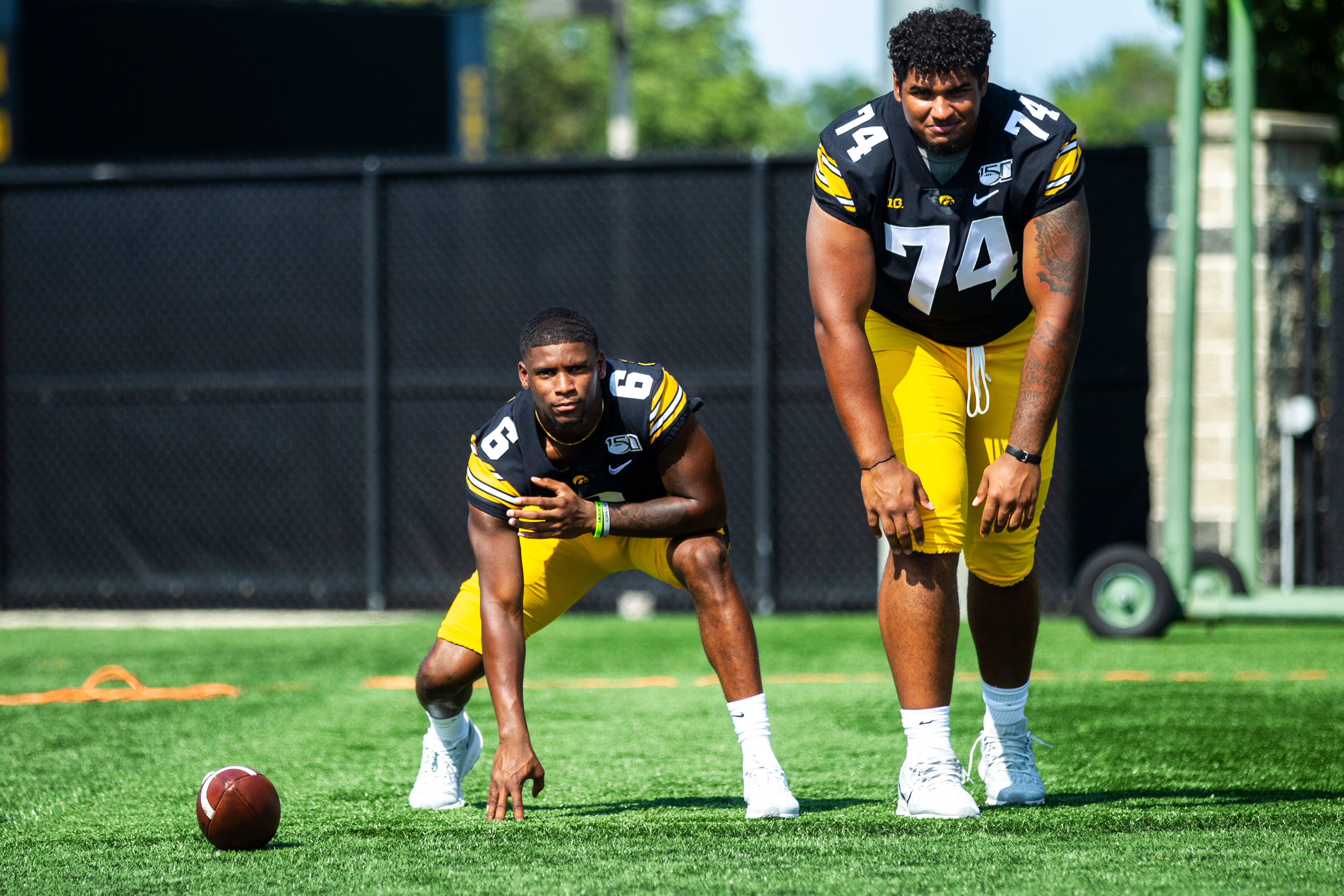 Iowa's Ihmir Smith-Marsette, left, and Tristan Wirfs swap positions while posing for a photo during Hawkeyes football media day, Friday, Aug. 9, 2019, at the University of Iowa outdoor practice facility in Iowa City, Iowa.