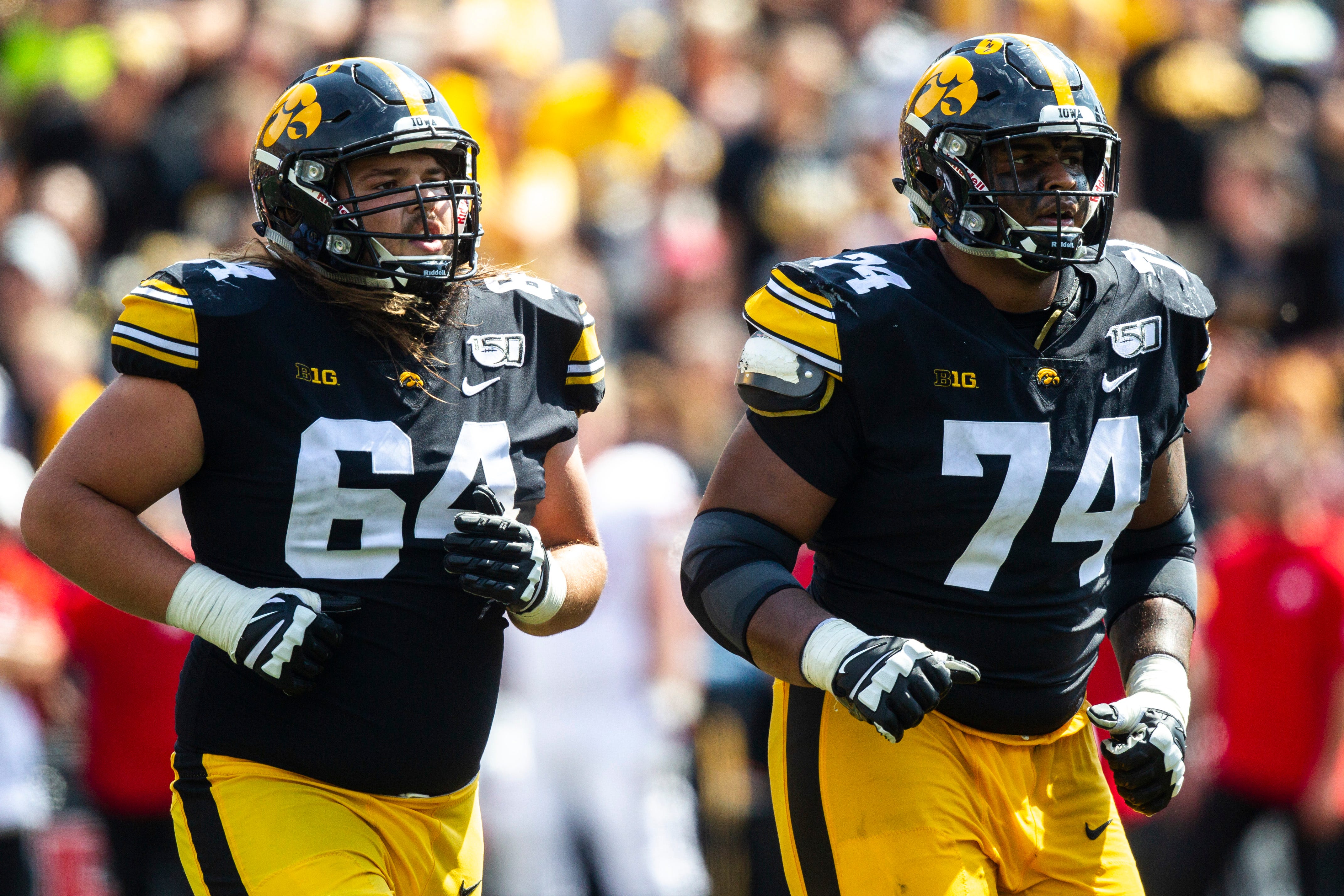 Iowa offensive lineman Kyler Schott (64) and Tristan Wirfs (74) run to the sideline during a NCAA Big Ten Conference football game against Rutgers, Saturday, Sept. 7, 2019, at Kinnick Stadium in Iowa City, Iowa.