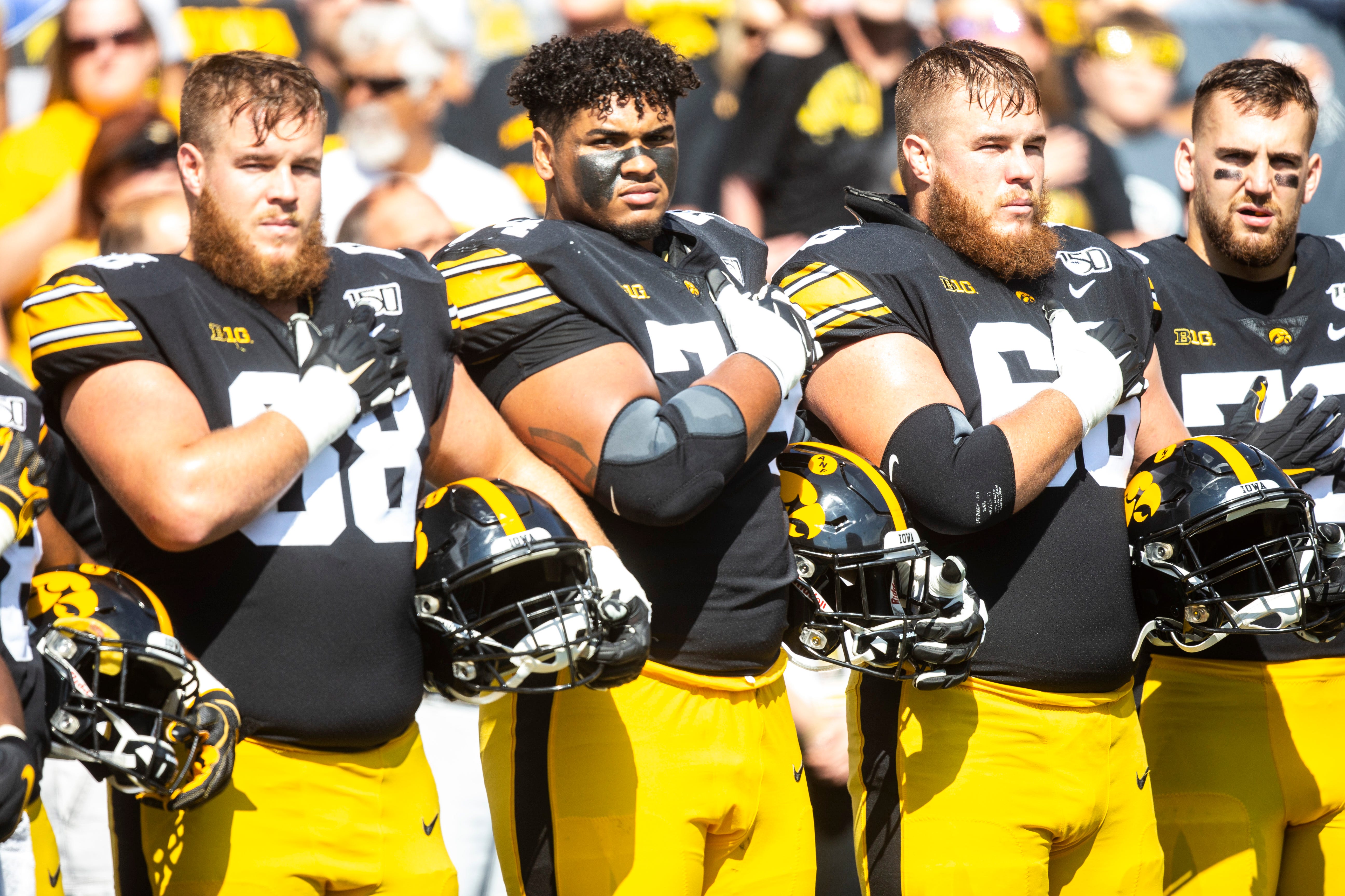 Iowa offensive lineman Landan Paulsen, from left, Tristan Wirfs and Levi Paulsen stand on the sideline before a NCAA Big Ten Conference football game against Rutgers, Saturday, Sept. 7, 2019, at Kinnick Stadium in Iowa City, Iowa.