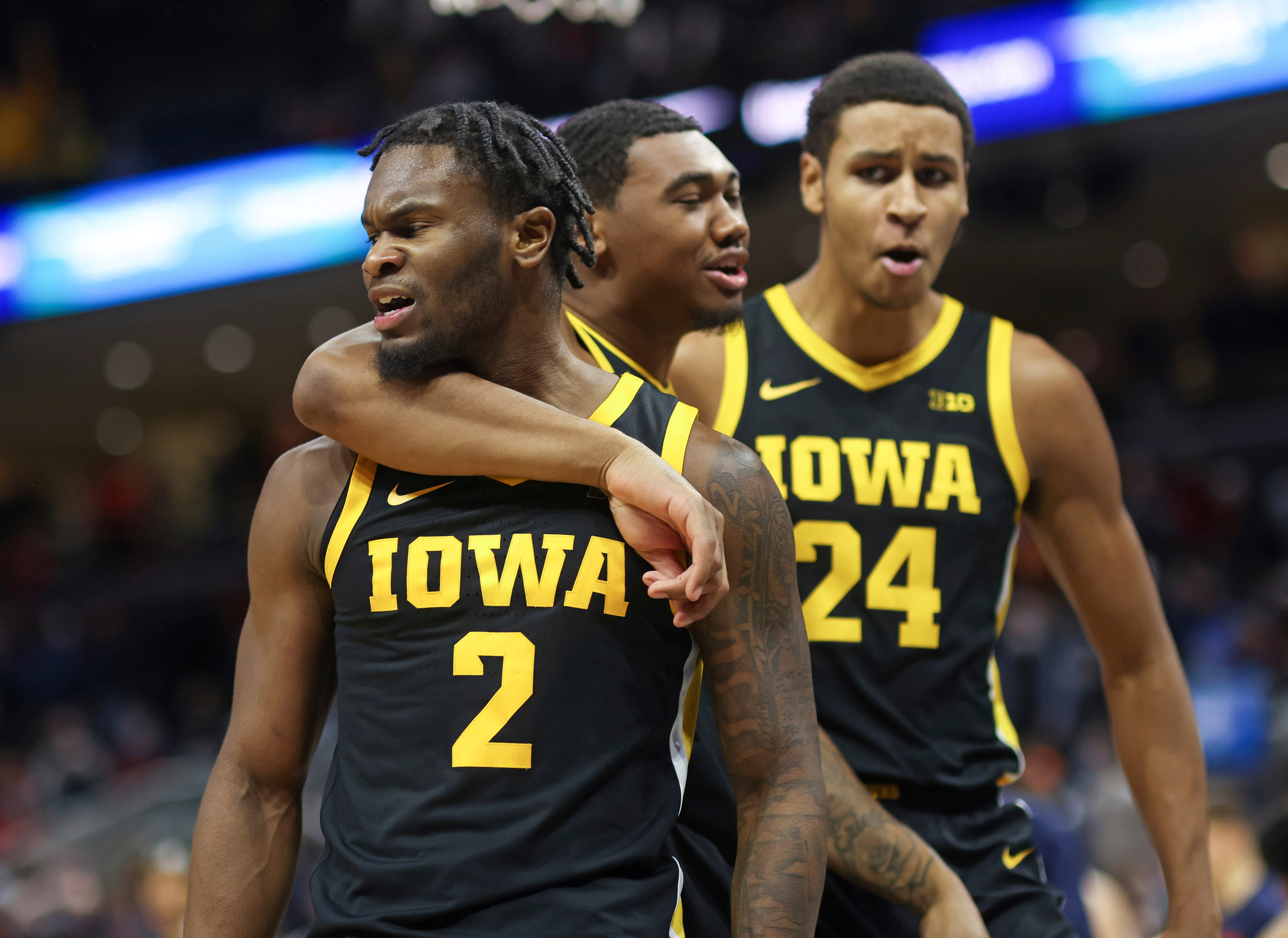 Iowa guard Joe Toussaint (2) celebrates the win over Virginia with teammates Tony Perkins (11) and Kris Murray (24) after an NCAA college basketball game, Monday, Nov. 29, 2021, in Charlottesville, Va.
