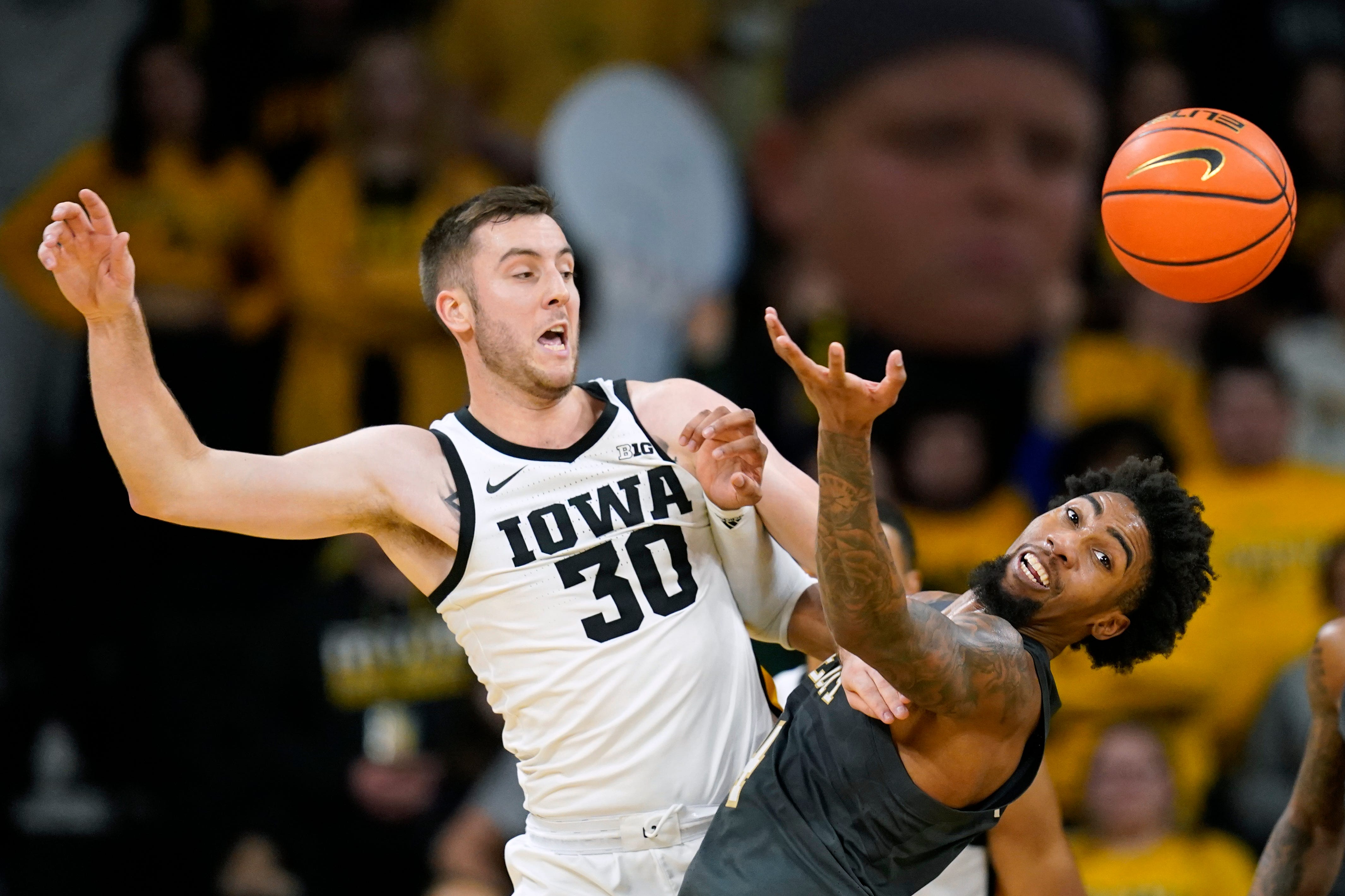 Iowa guard Connor McCaffery (30) fights for a loose ball with Georgia Tech forward Ja'von Franklin during the second half of an NCAA college basketball game, Tuesday, Nov. 29, 2022, in Iowa City, Iowa.