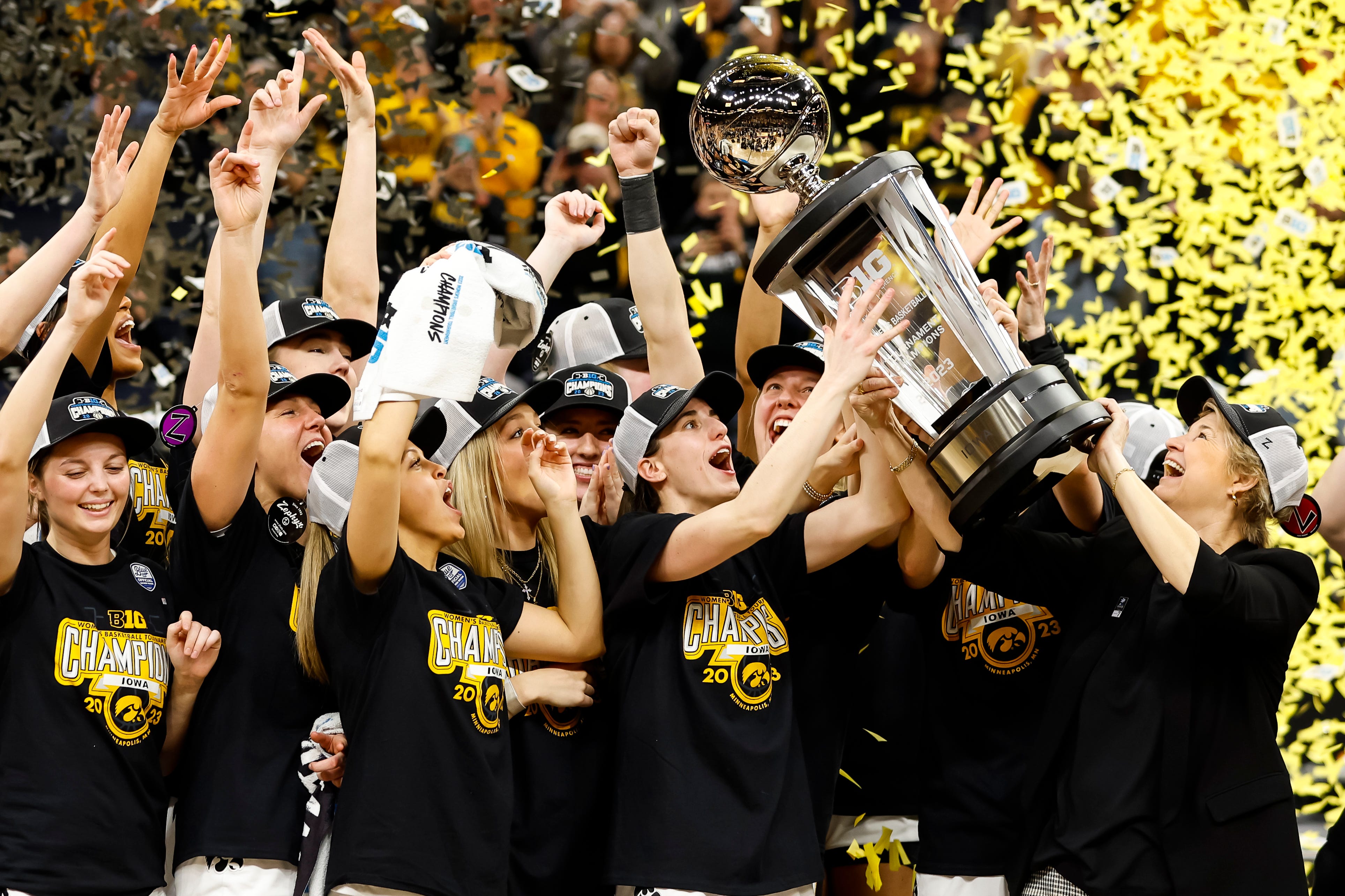 Iowa guard Caitlin Clark and head coach Lisa Bluder lift the trophy while the Hawkeyes celebrate their victory against the Ohio State Buckeyes with the trophy after the championship game of the Big Ten Women's Basketball Tournament at Target Center on March 5, 2023 in Minneapolis, Minn. The Hawkeyes defeated the Buckeyes 105-72.