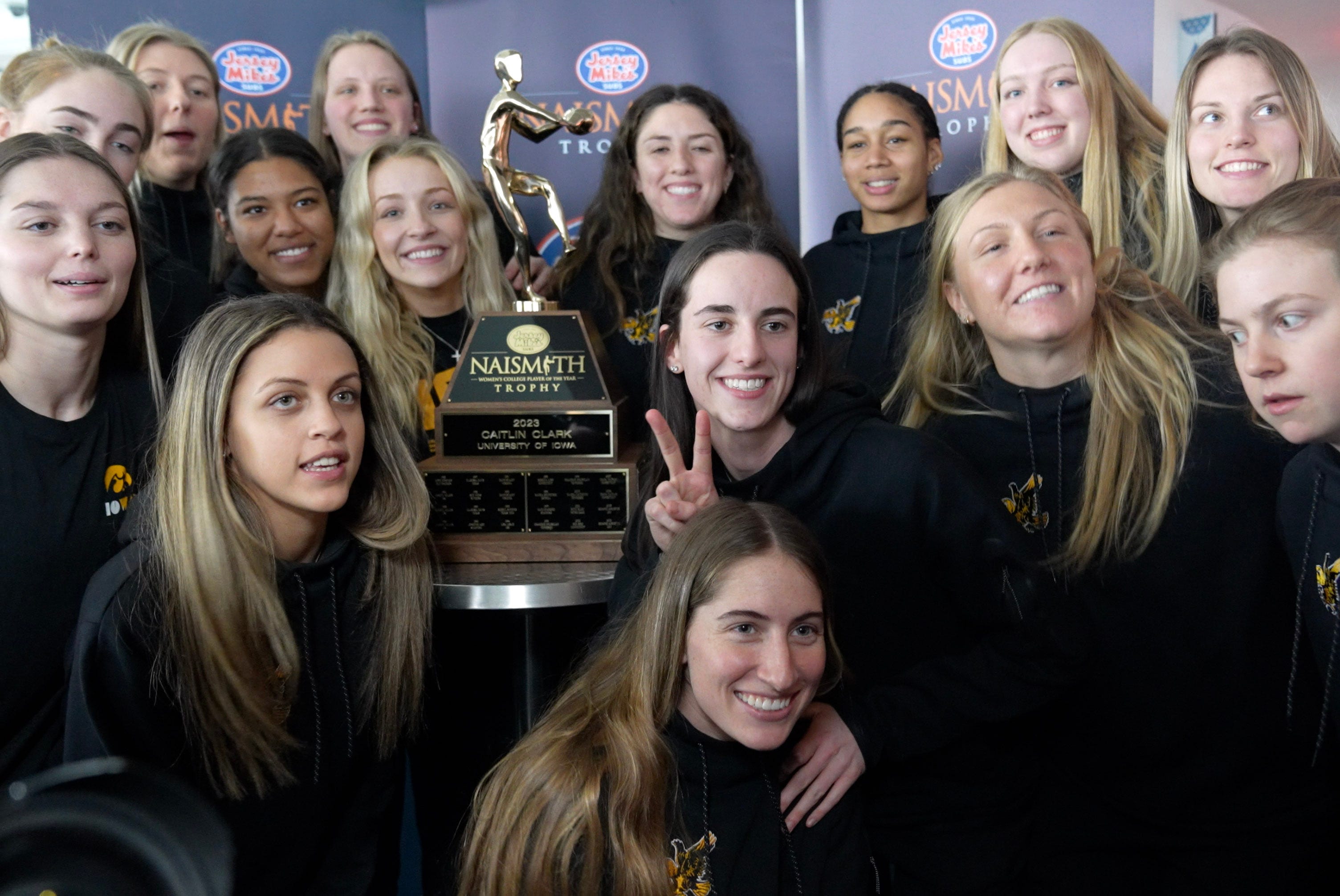 Caitlin Clark poses for photos with her team after winning the 2023 Jersey Mike's Naismith Trophy in Dallas, Texas, Wednesday, March 29, 2023.